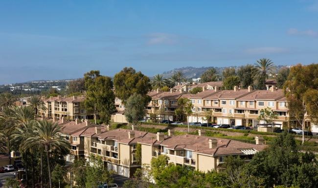 a group of houses with trees in the front